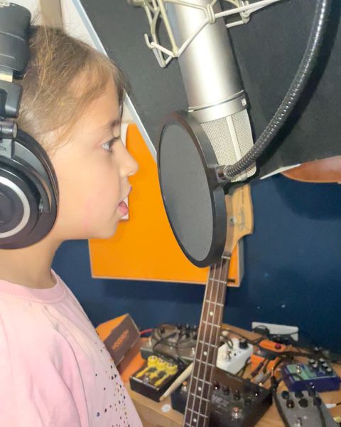 A young singer in headphones at the microphone